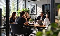 Neformální setkání u kávy v moderní zasedací místnosti, které ilustruje osobní a přátelský přístup marketingové agentury MOON WOLF.